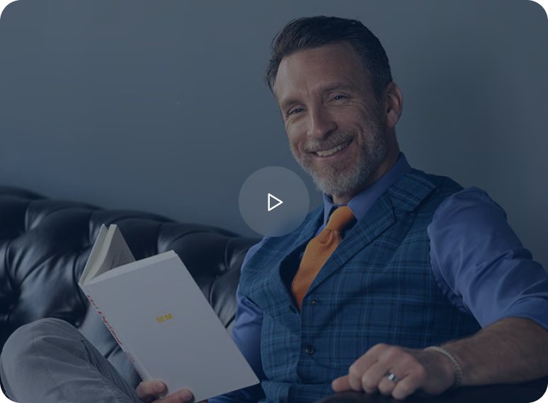 Mike Michalowicz holding a copy of Profit First