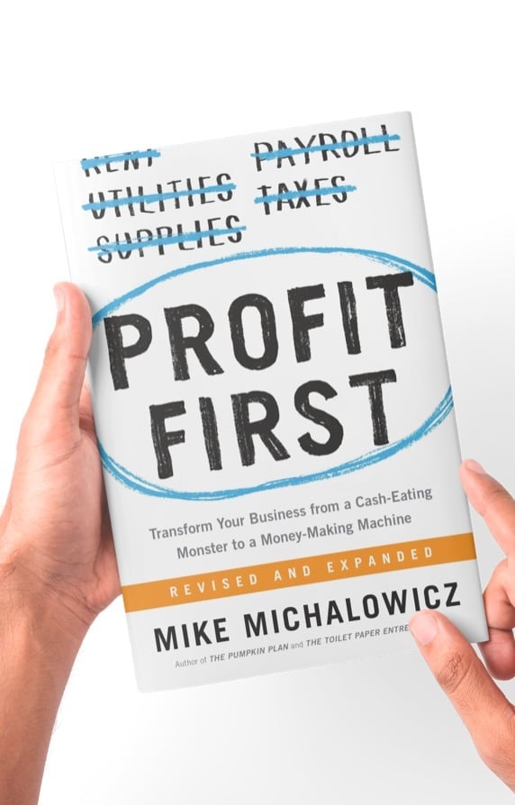 A copy of Profit First by Mike Michalowicz, held open to the camera