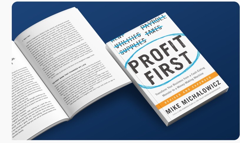An open copy of Profit First beside its cover, on a navy background